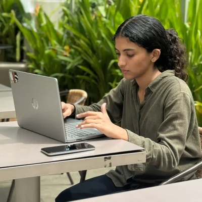 digital-marketing-freelancer-in-mumbai A digital marketing freelancer in Mumbai working on a laptop at an outdoor table.